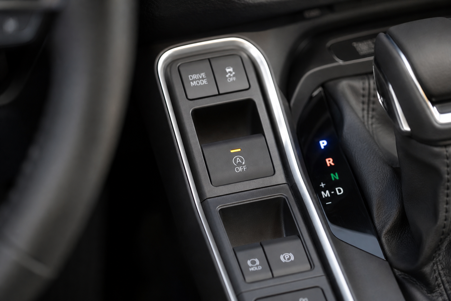 Close-up of the auto start/stop disable button on a Toyota Grand Highlander center console