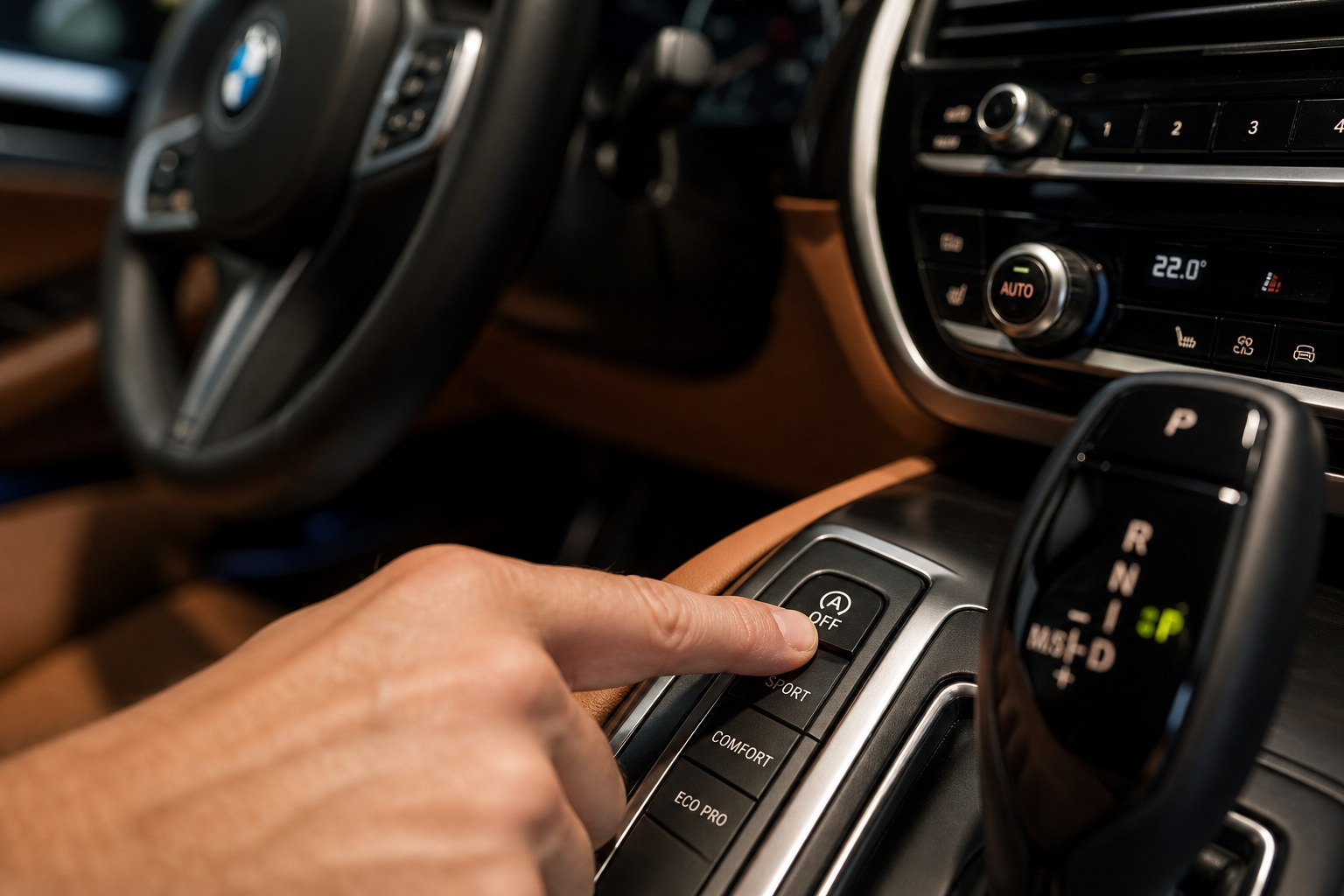 Finger pressing the auto start/stop button on a BMW 5 Series center console