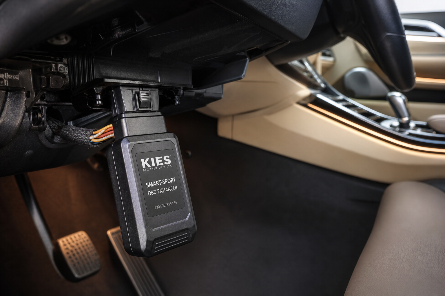 A start/stop eliminator module being plugged into a car's wiring harness under the dashboard
