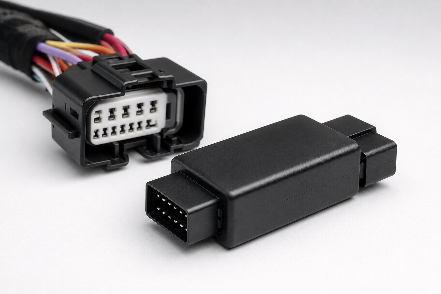 A small black auto start-stop eliminator module with wiring harness connectors