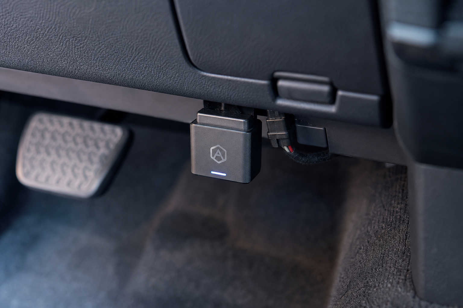 Auto start stop eliminator module plugged into a vehicle OBD2 port under the dashboard