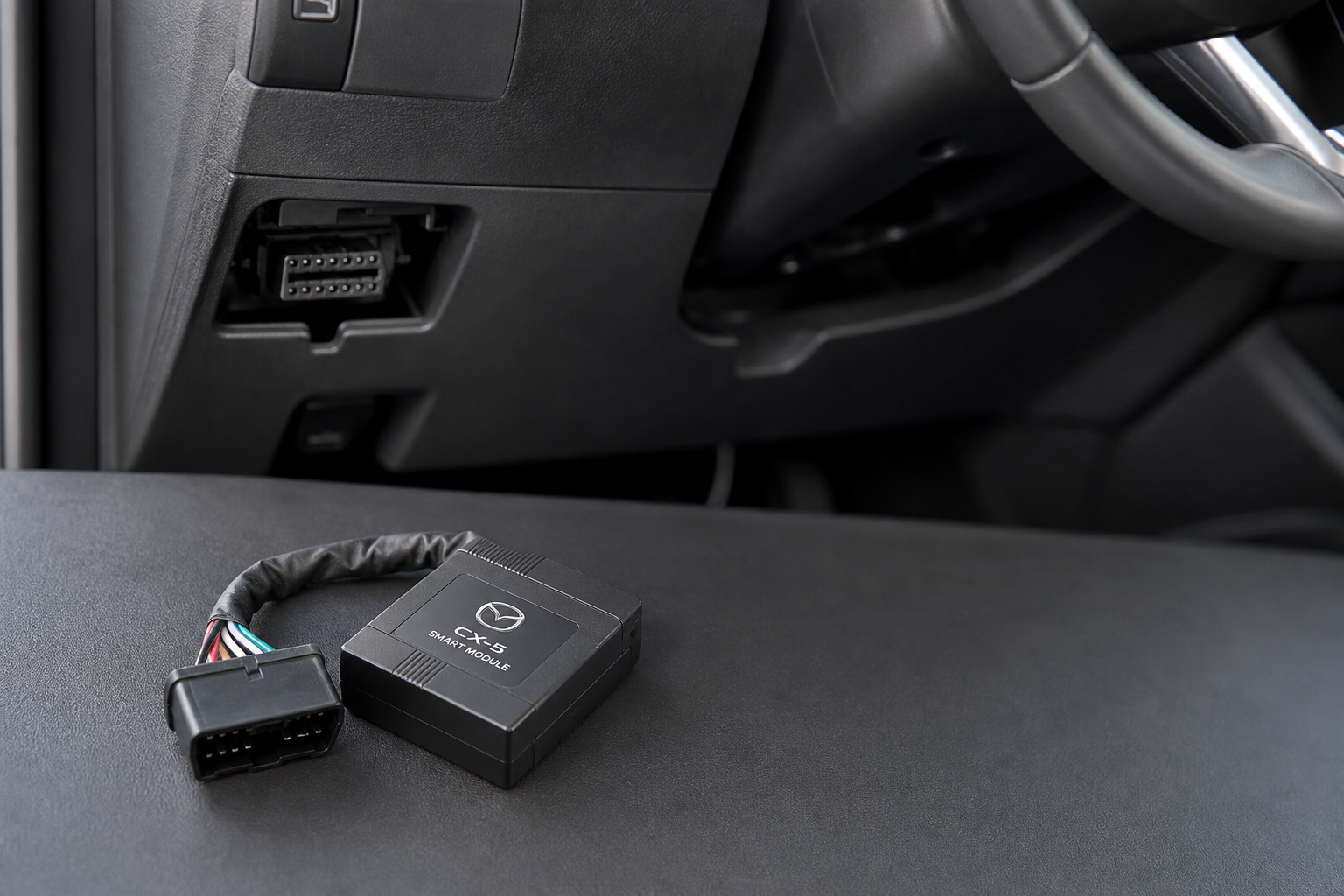 An i-stop eliminator module placed near the OBD port under a Mazda CX-5 dashboard