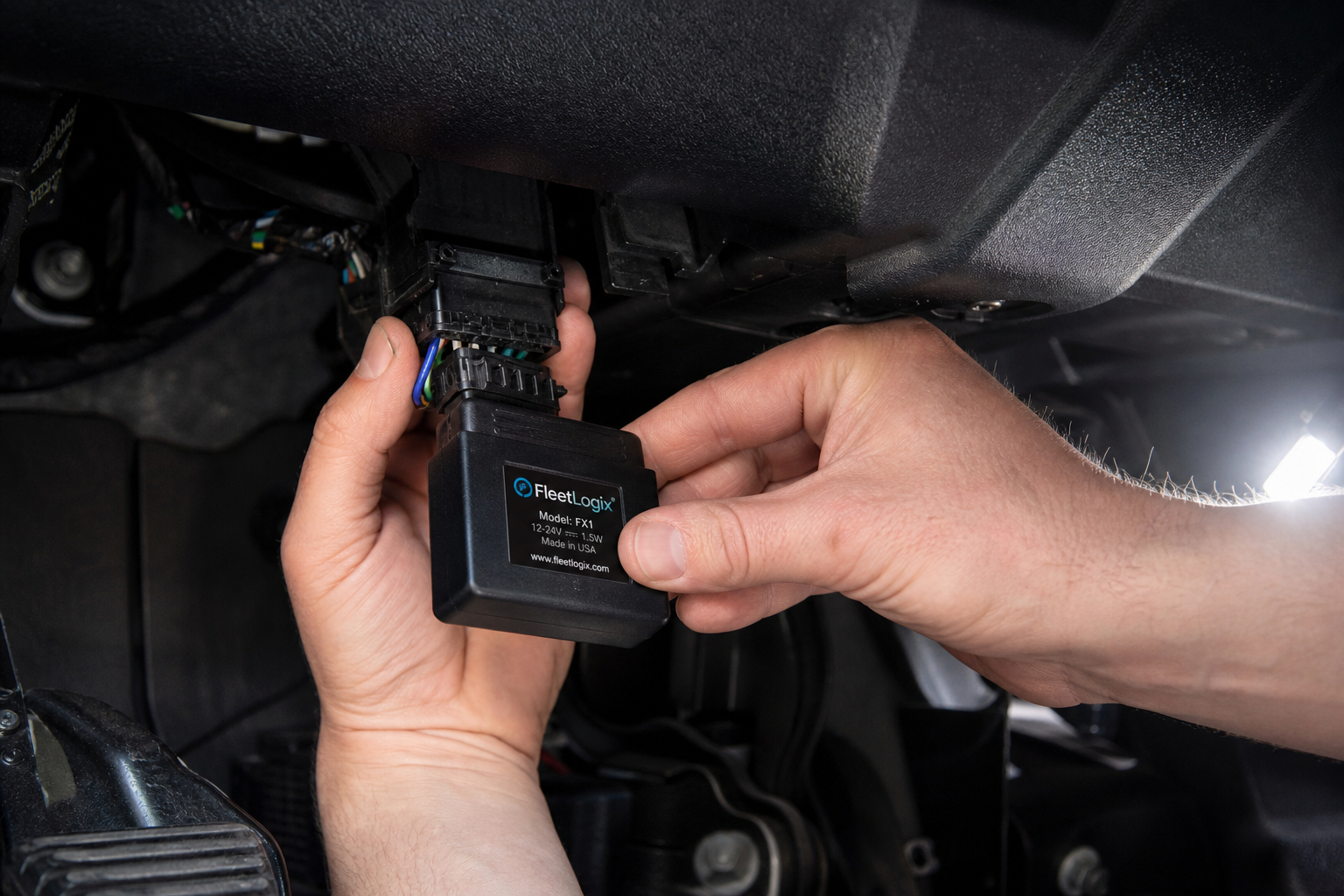 A small electronic start-stop eliminator module being plugged into a truck wiring harness