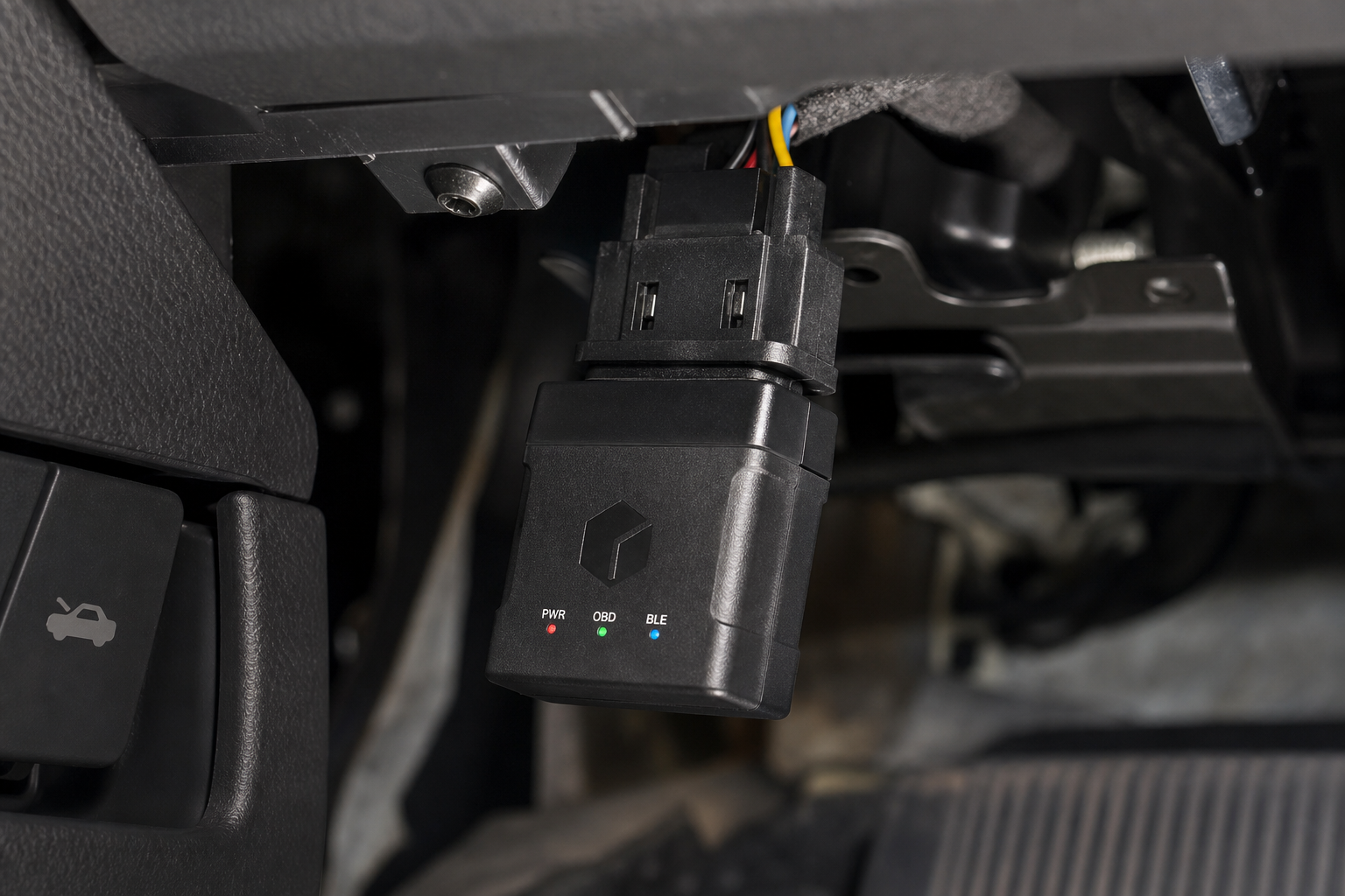 A small start/stop eliminator module plugged into a car's wiring harness under the dashboard