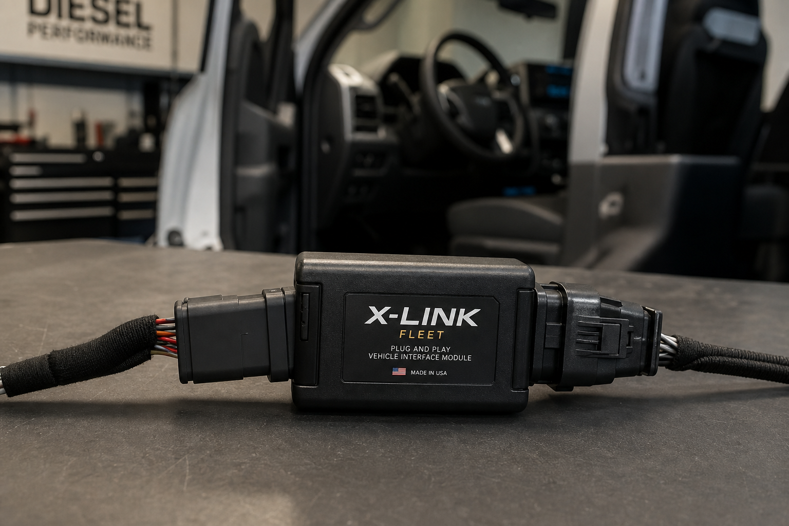 Plug-and-play auto start/stop eliminator module next to a truck wiring harness connector on a workbench