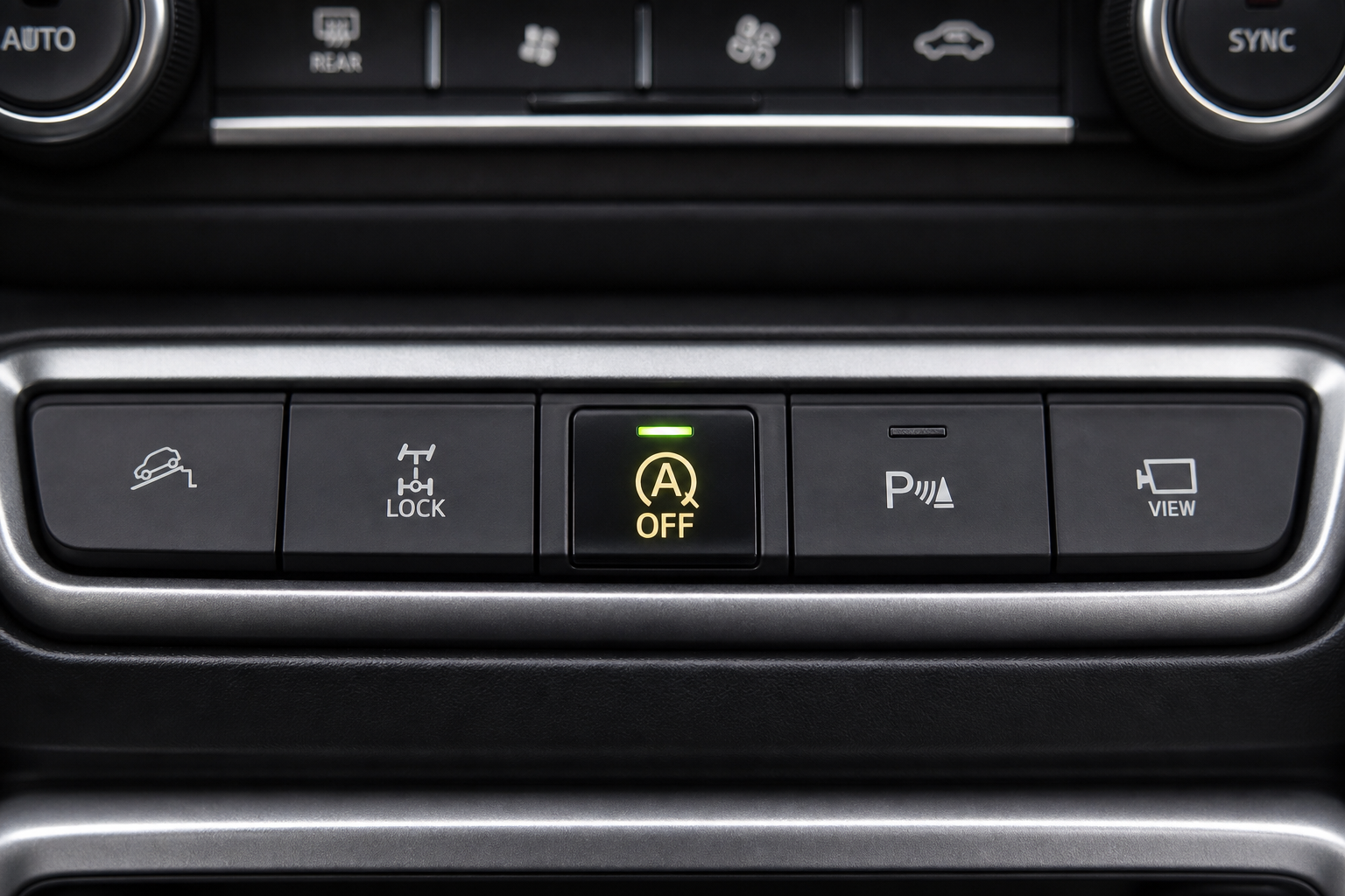 Close-up of the Auto Start Stop disable button on a Jeep Renegade dashboard center console