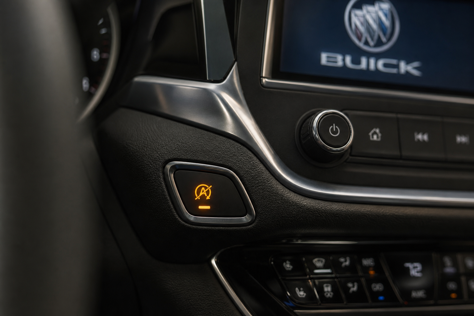 Close-up of the auto start/stop disable button on a Buick Envision dashboard