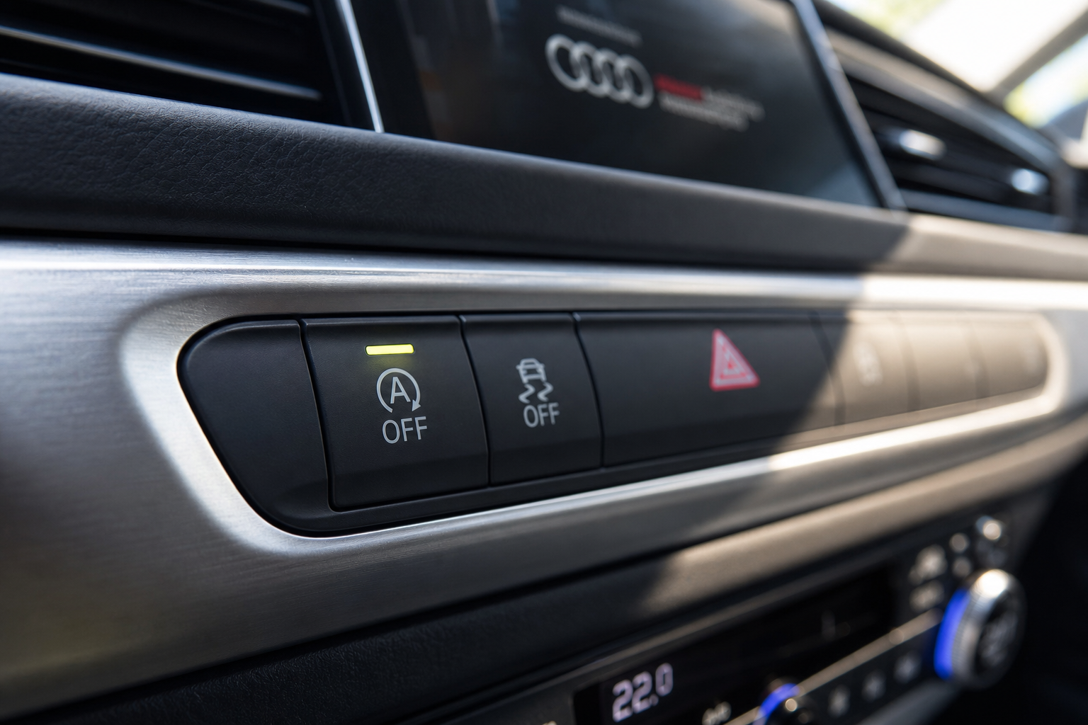 Illuminated auto start/stop disable button on a luxury SUV dashboard center console