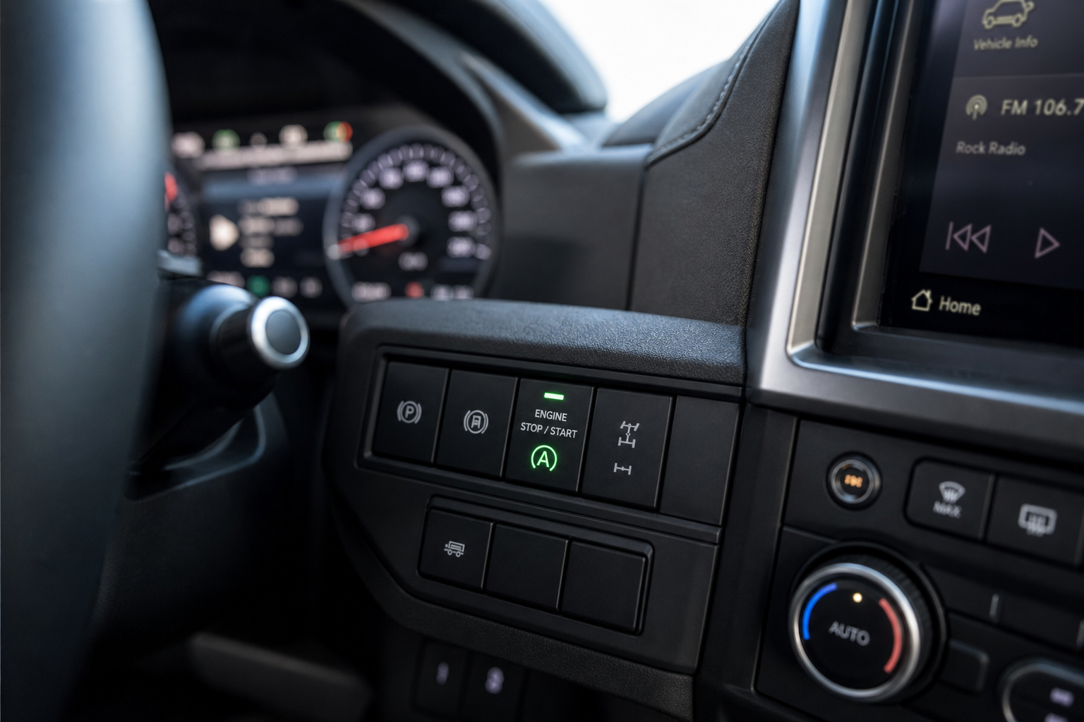 Close-up of the auto start/stop button on a truck dashboard
