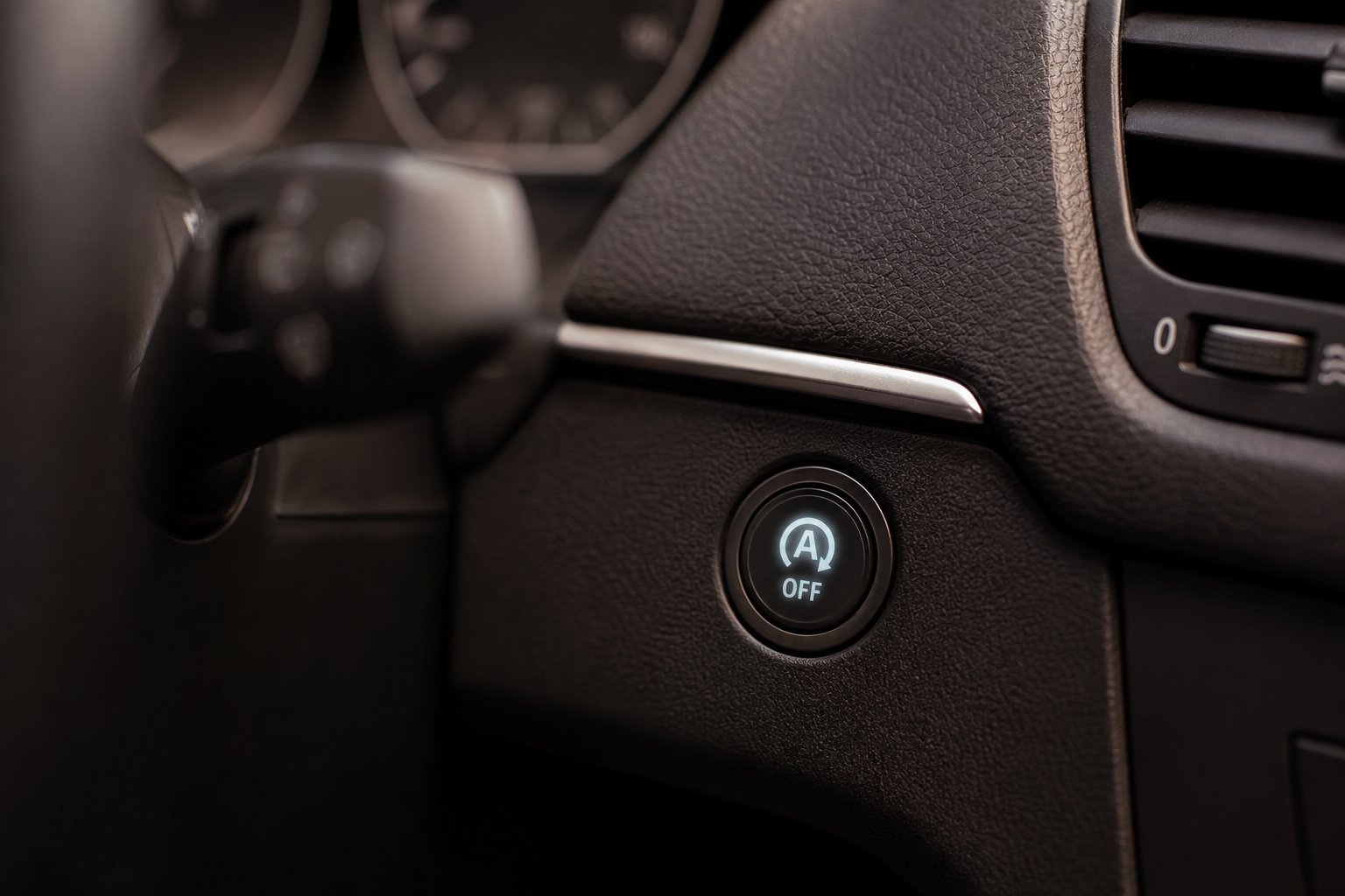 Close-up of the auto start-stop button on a car dashboard