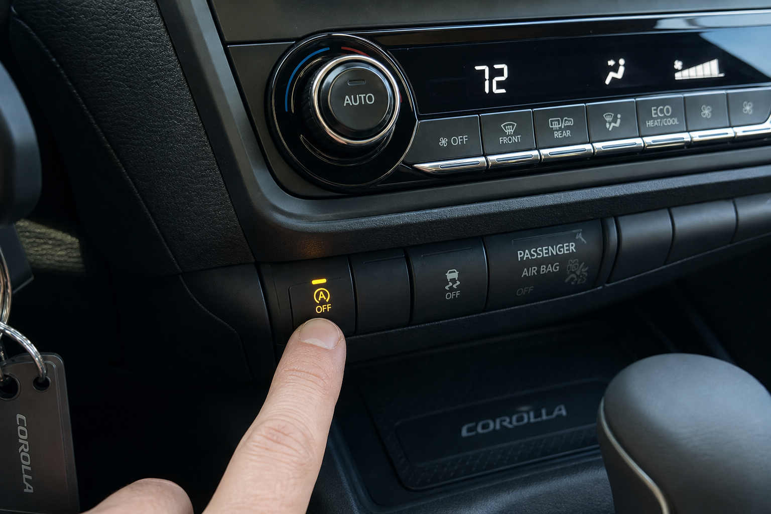 Driver pressing the auto start-stop disable button on a Toyota Corolla dashboard