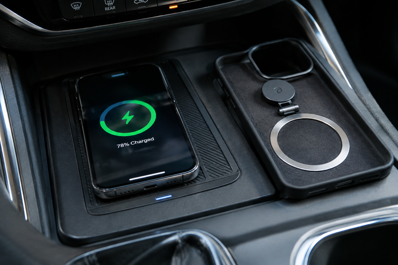 Phone case with metal accents and magnetic accessory next to a wireless charging pad