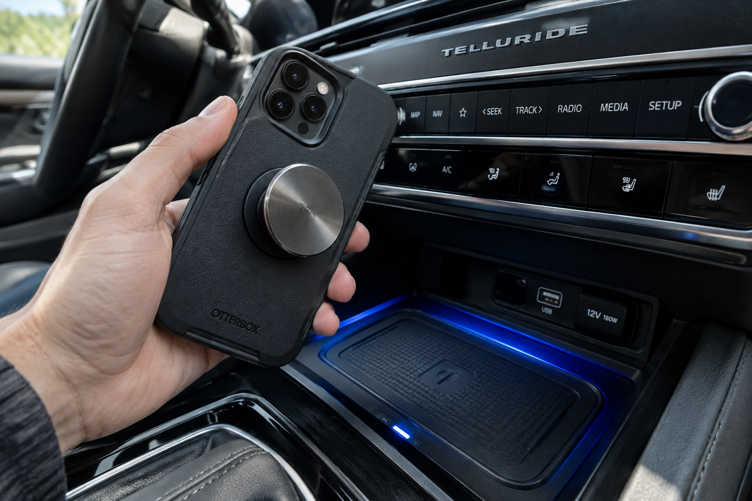 Smartphone with thick case and accessory held above a car wireless charging pad