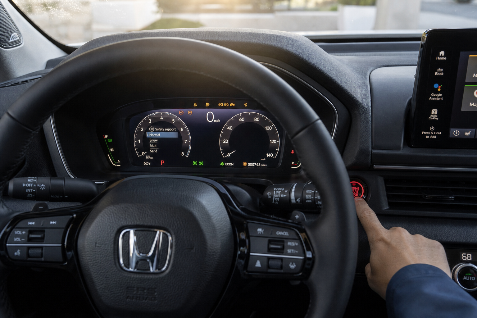 Hand pressing Honda Pilot start button with dashboard lighting up