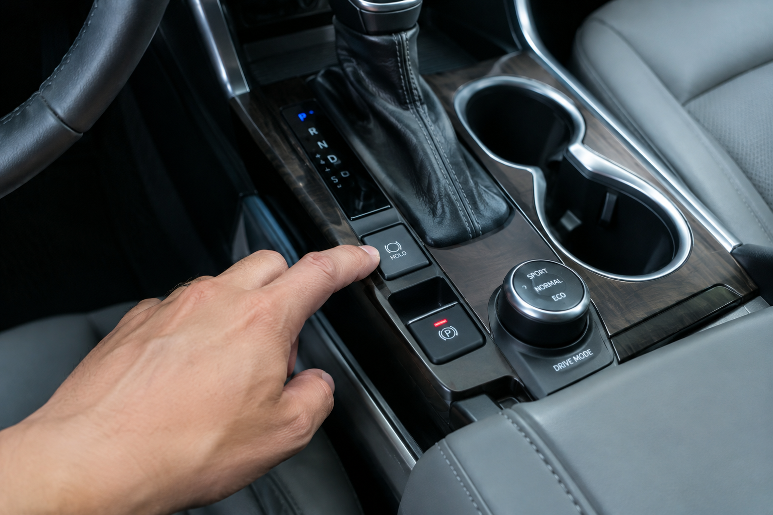 Hand pressing the Brake Hold reset button in a Toyota Highlander
