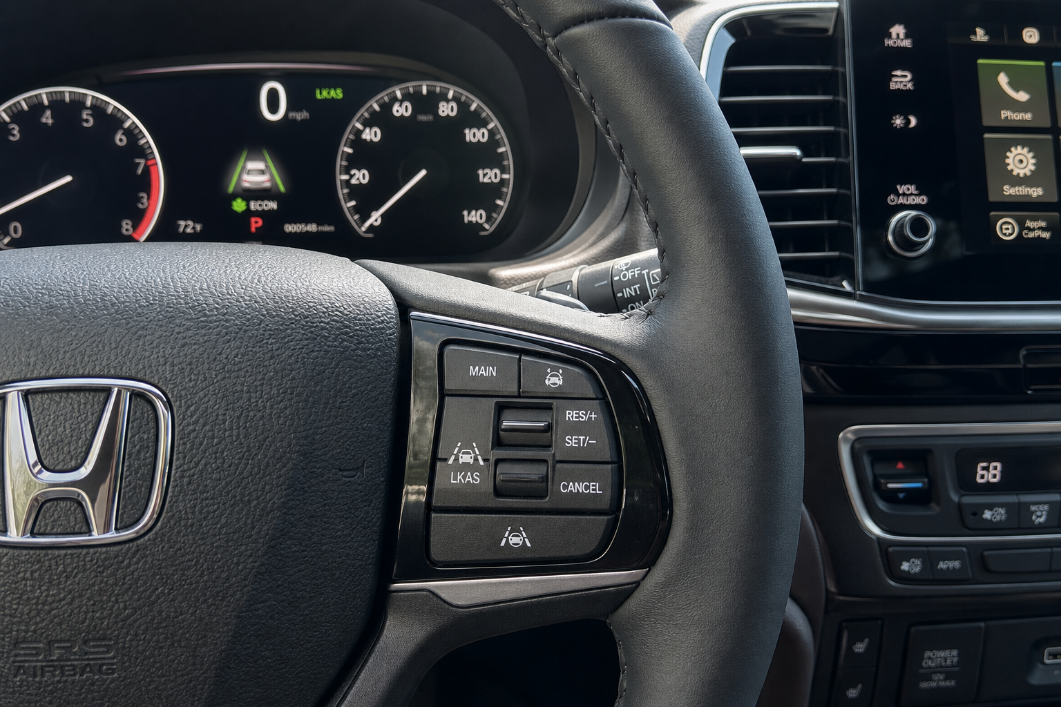 Close-up of Honda Pilot steering wheel showing lane keeping assist button