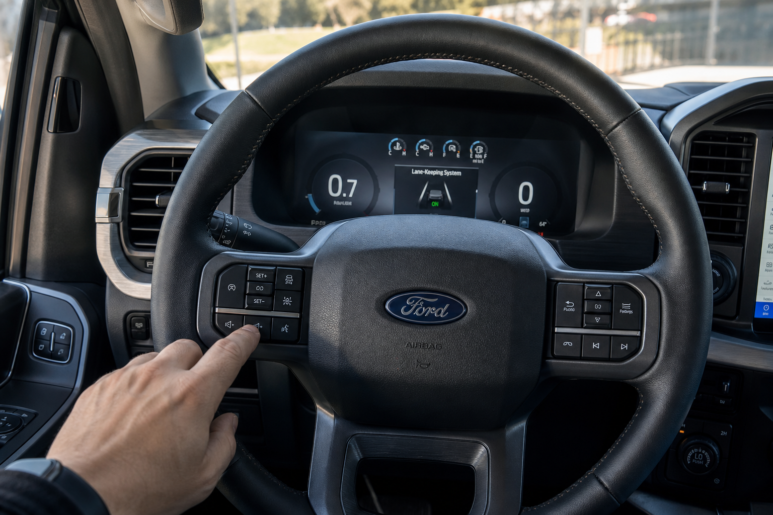 Hand pressing the lane-keeping assist button on a Ford F-150 steering wheel