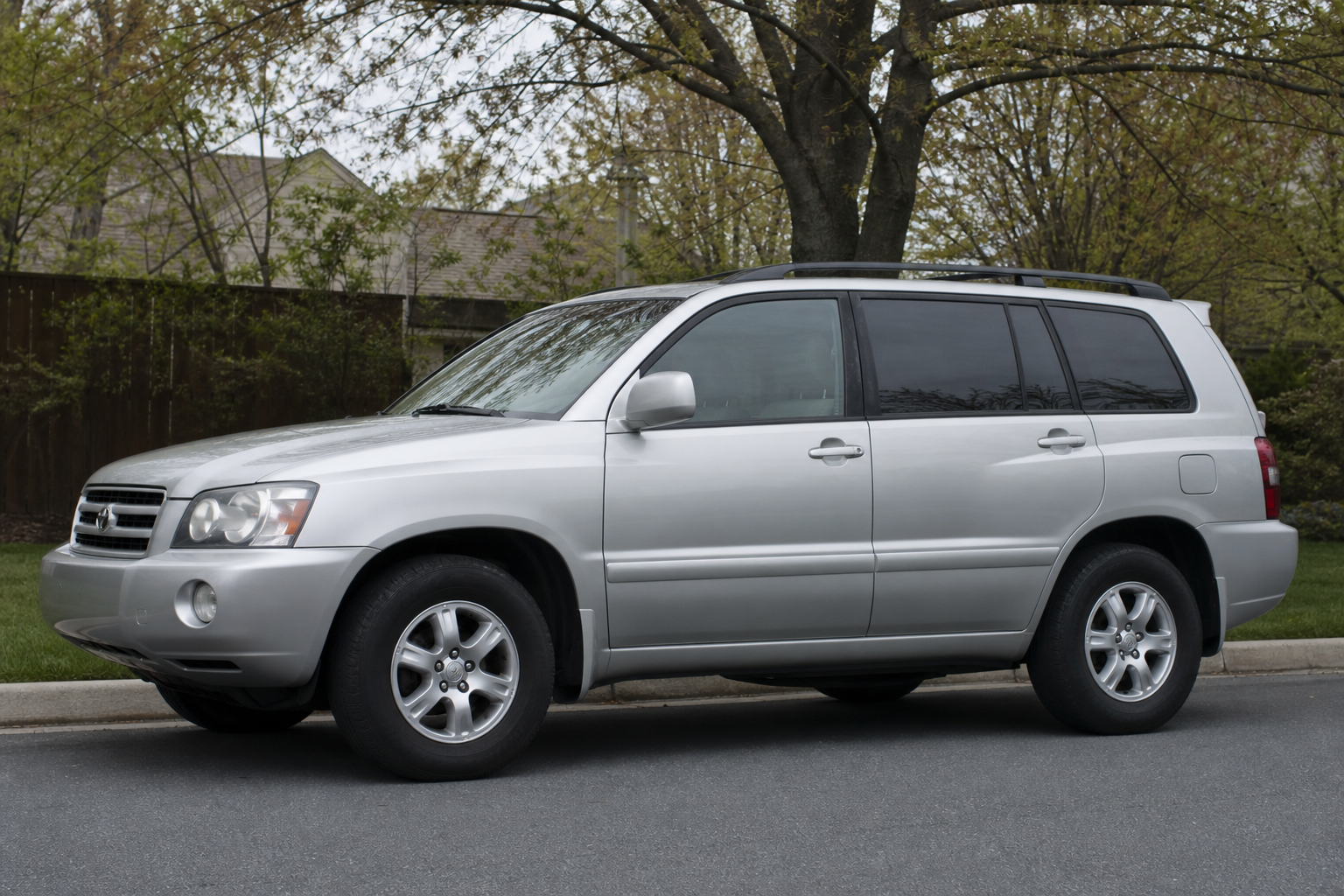 Older model Toyota Highlander SUV parked on a suburban street