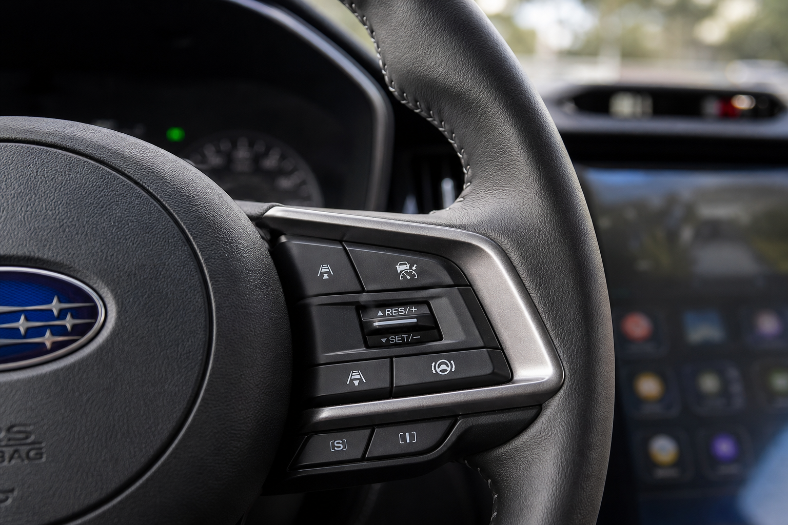 Close-up of steering wheel cruise control buttons on a Subaru Outback