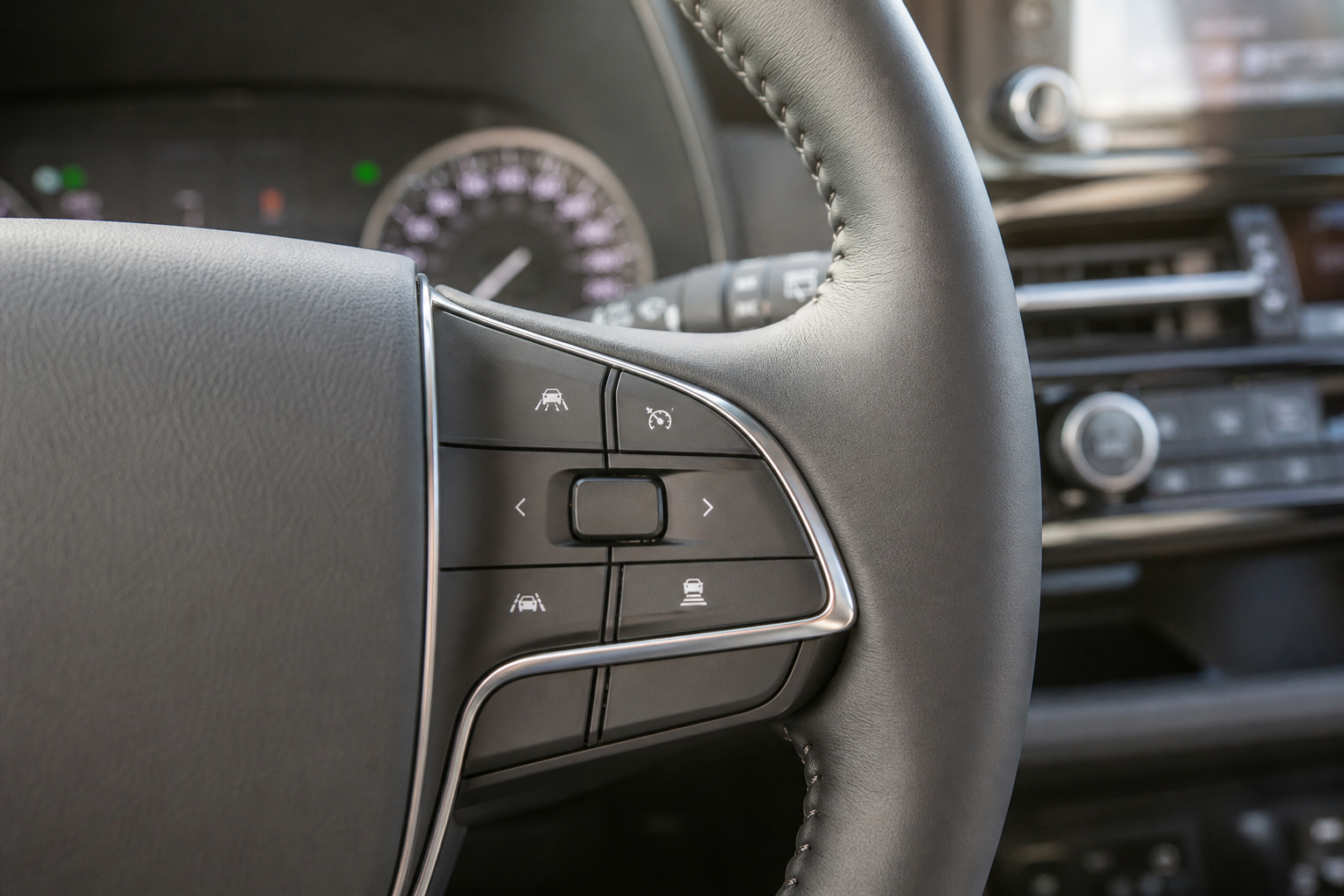 Close-up of steering wheel buttons used to control dynamic radar cruise control on a Toyota Highlander