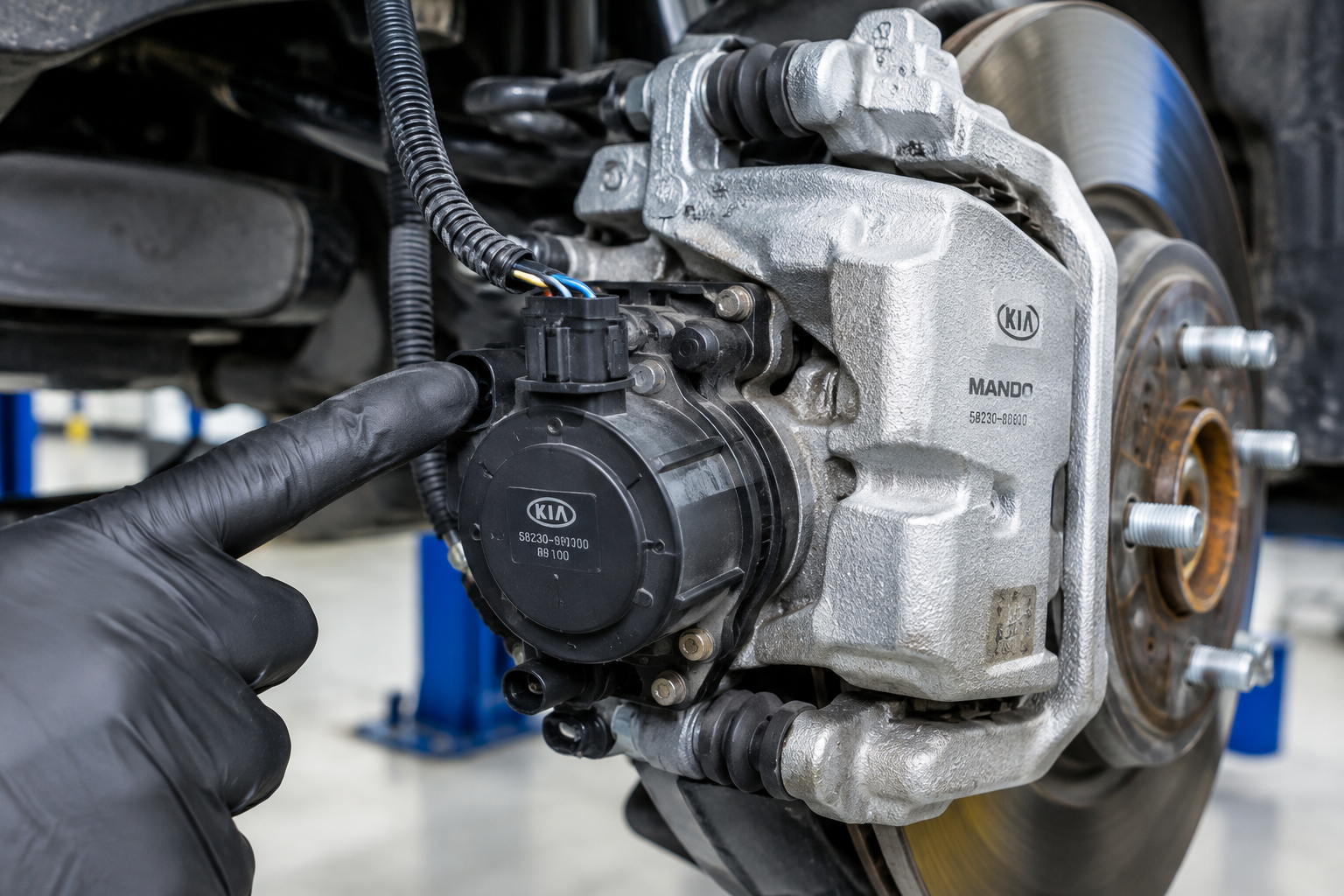 Close-up of electronic parking brake actuator and wiring on a rear brake caliper
