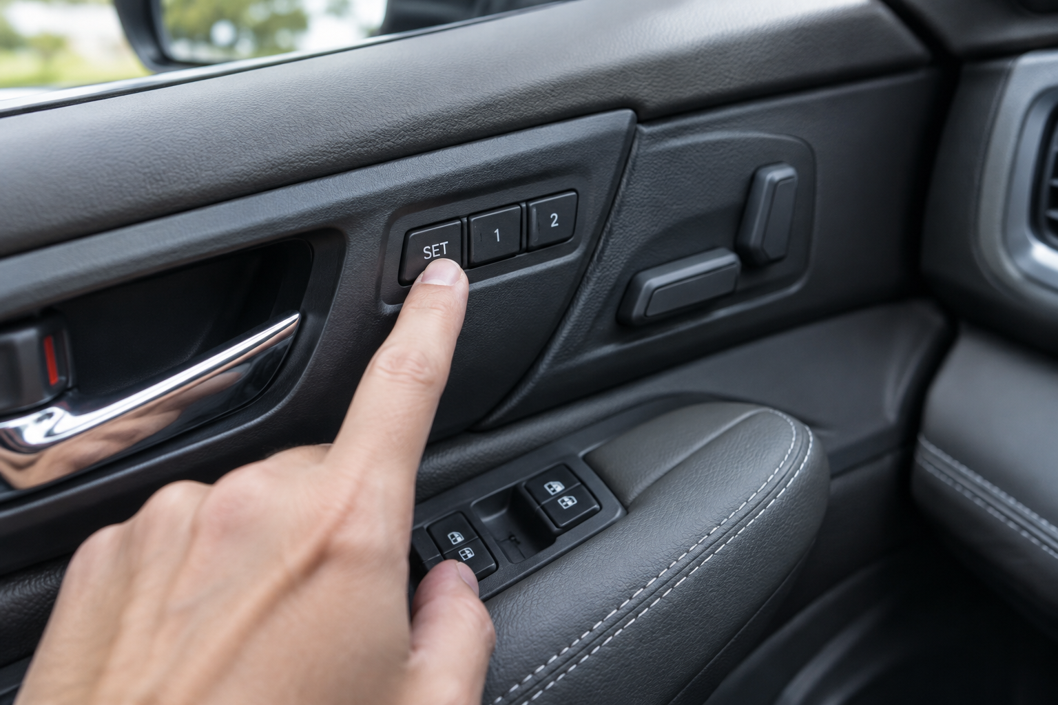 Hand pressing the memory seat set button on a Subaru Outback door panel