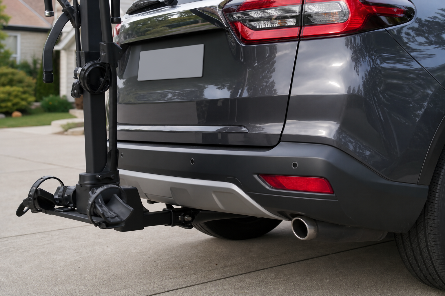 Tow hitch and bike rack installed on a car bumper near parking sensors