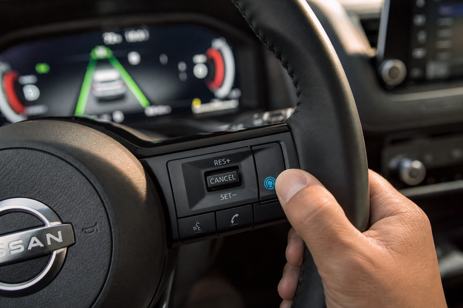 Hand pressing ProPILOT Assist steering button on Nissan Rogue steering wheel