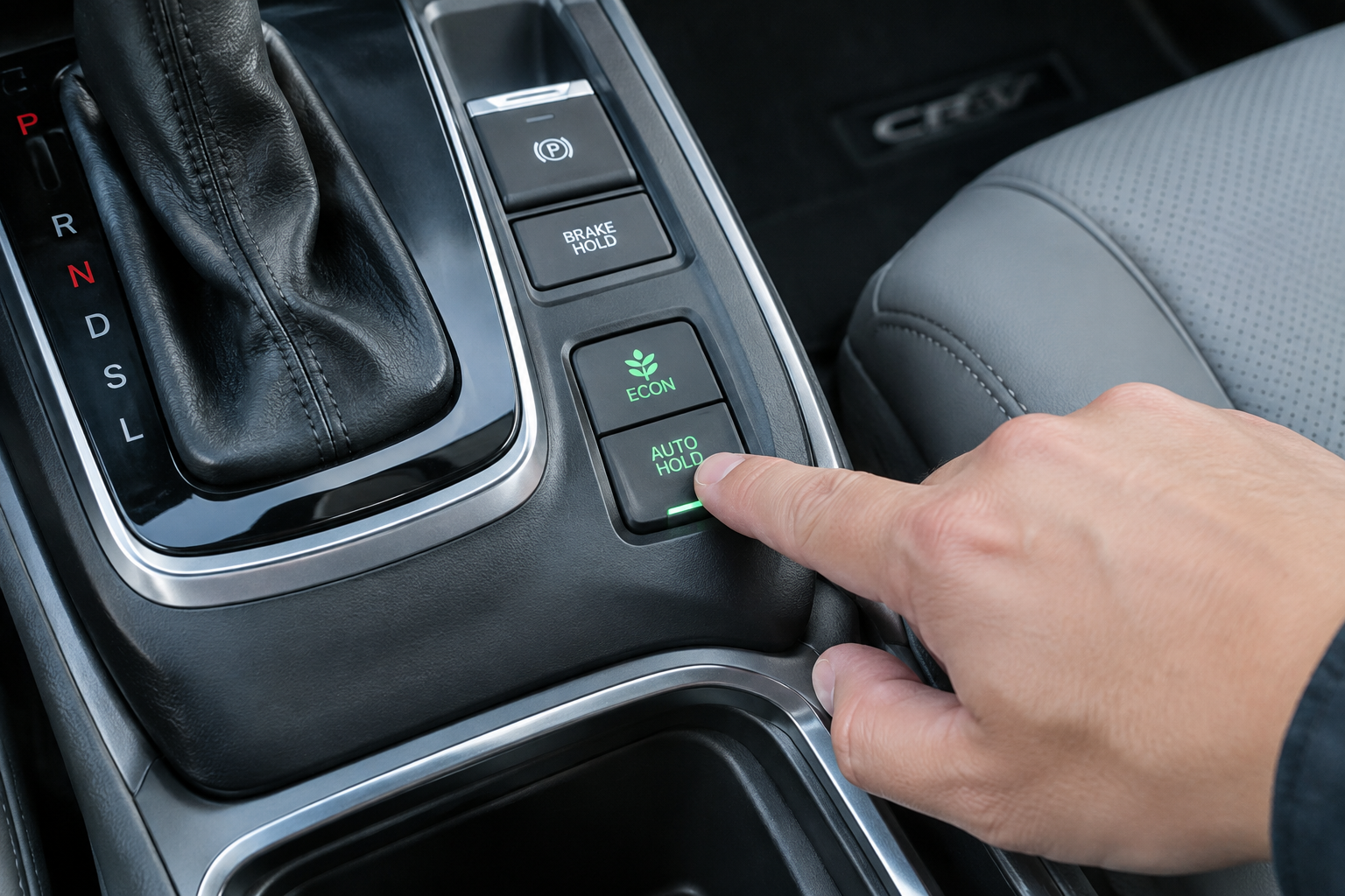 Close-up of the Auto Hold button being pressed in a Honda CR-V center console