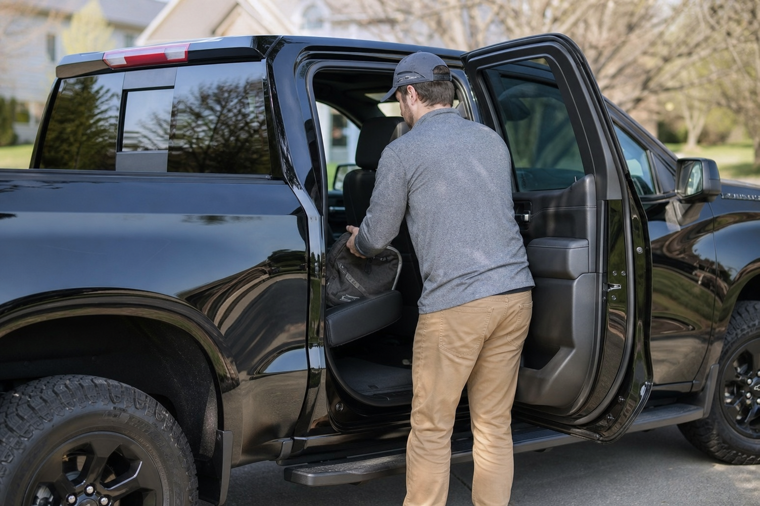 Rear door of a Chevy Silverado open showing someone placing an item on the back seat