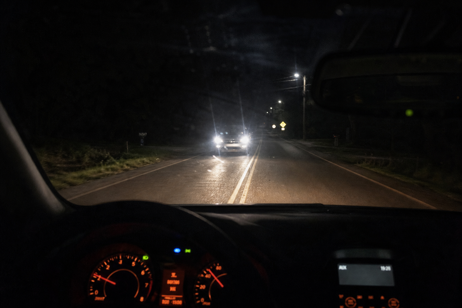 Driver's view of oncoming traffic at night illustrating reasons to disable automatic high beams